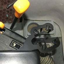 Metal cup holder for Case IH 2188 combine cab mounted on the arm rest.